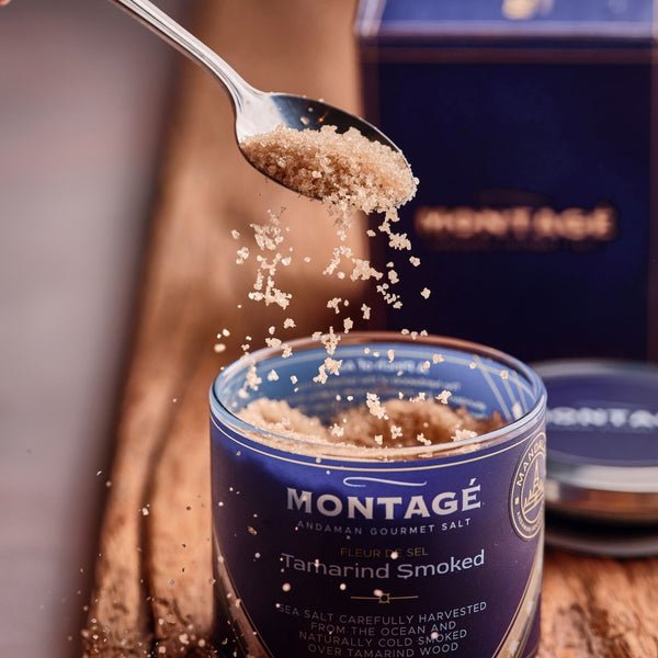 Spoonful of Montagé Tamarind Smoked Sea Salt being poured into the open jar