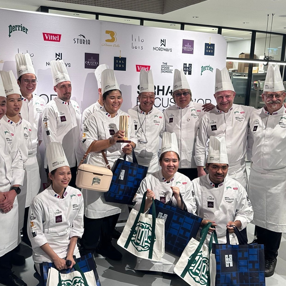 Chefs in Bocuse d'Or Thailand jackets holding a trophy at the event where Montagé salt is used