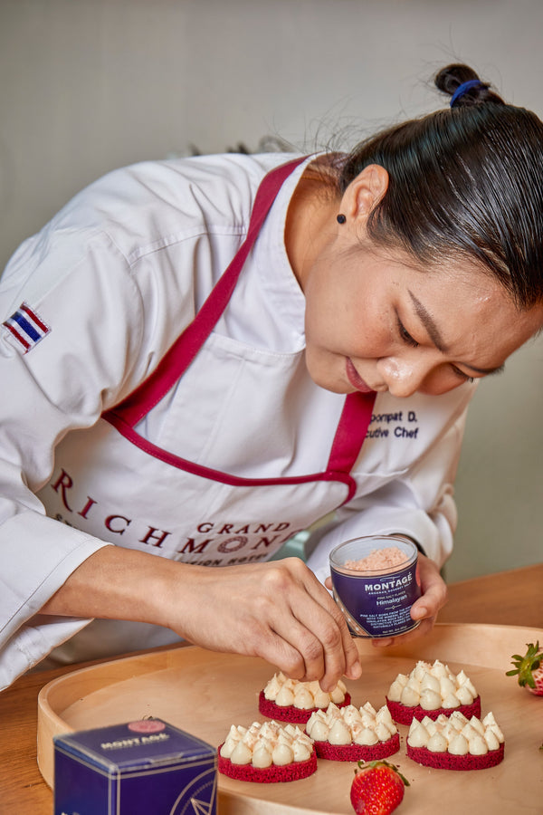 Pastry chef sprinkling Montagé Himalayan pink flake salt over a plated dessert for a fine-dining finish